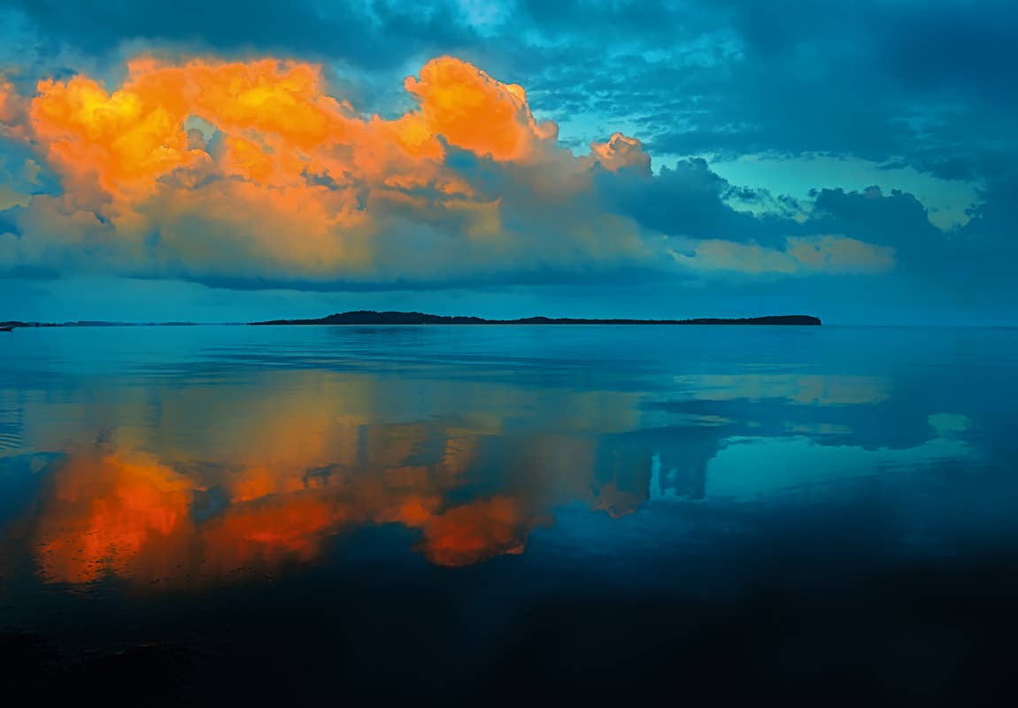 Foto von orange glühenden Wolken über einer Insel